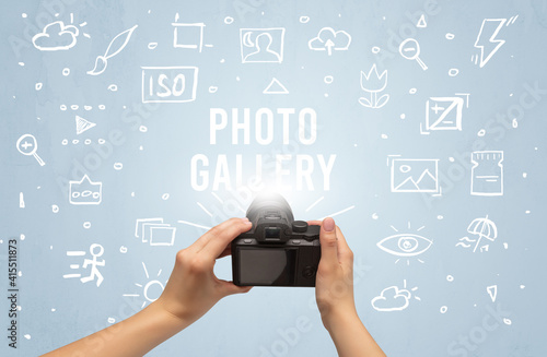 Hand taking picture with digital camera and PHOTO GALLERY inscription, camera settings concept