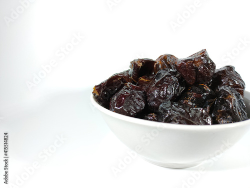 Selective focus.Dried sweet dates on bowl isolated on white background. Healthy food concept.