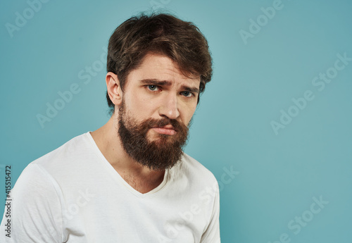 Portrait of a handsome man on a blue background with a cropped beard look