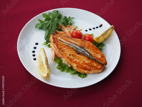 Baked salmon in foil on a red background