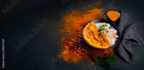 Indian butter chicken curry with basmati rice on dark background. Traditional homemade food concept.