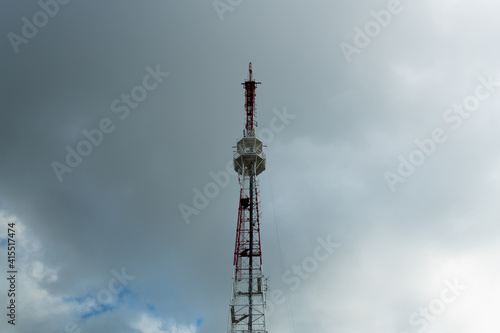 Telecommunication tower against the background of a gloomy gray sky, cell antenna, transmitter. TV tower