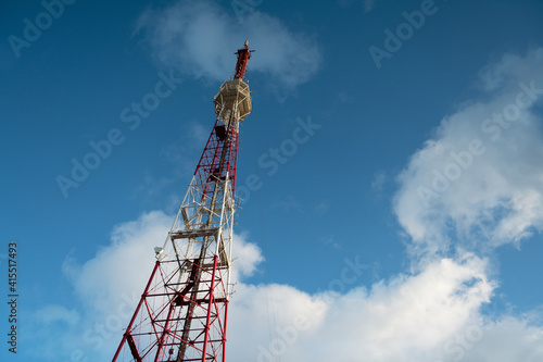 Telecommunication tower against the blue sky with the clouds, cell antenna, transmitter. TV tower