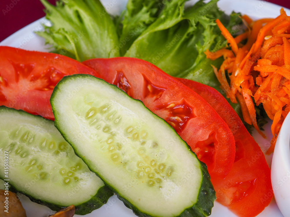 Chicken kebab with tomato and greens on a red background Chicken kebab with tomato and greens on a red background