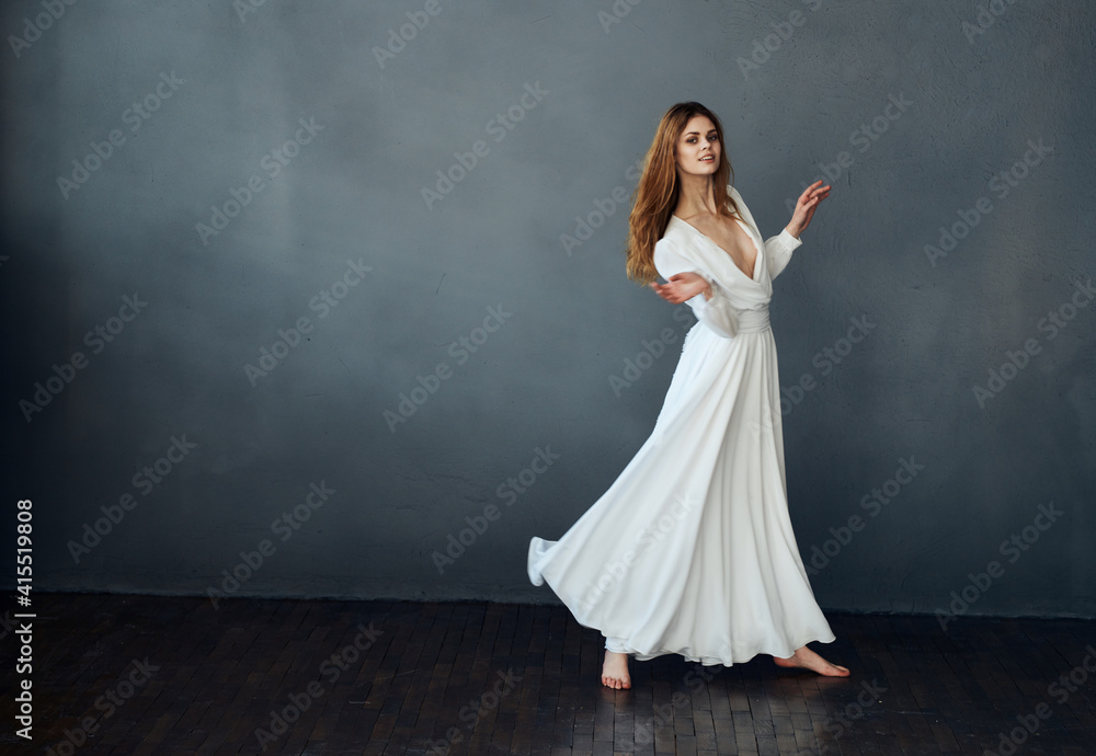 Charming lady in a white dress on a gray background dance gesticulating with her hands Copy Space model Charming lady in a white dress on a gray background dance gesticulating with her hands Copy Space model