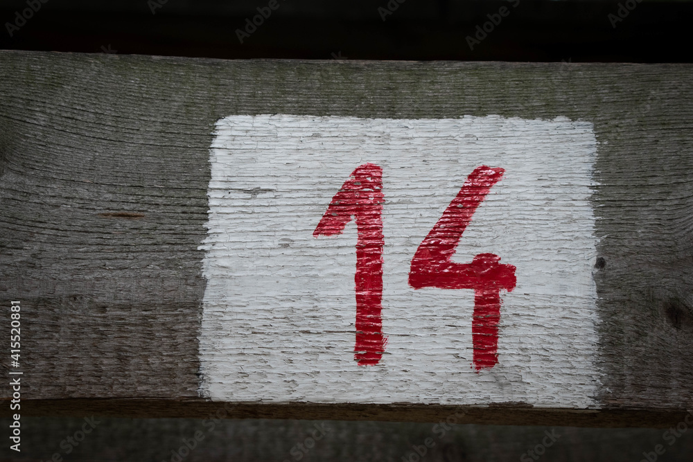 Closeup shot of number 14 on a wooden surface - obrazy, fototapety, plakaty 