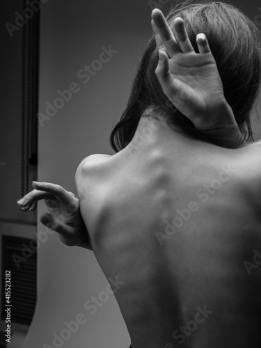 Black and white photo of a long hair model touching herself with hands