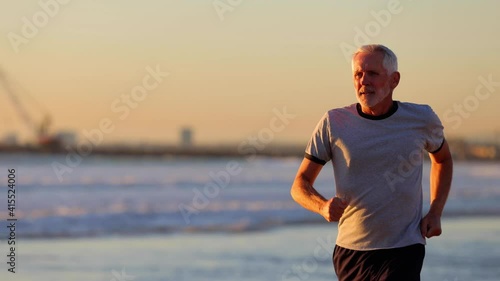 Wallpaper Mural 64 year old man getting his exercise at the beach at sunset. Slow Motion. Torontodigital.ca