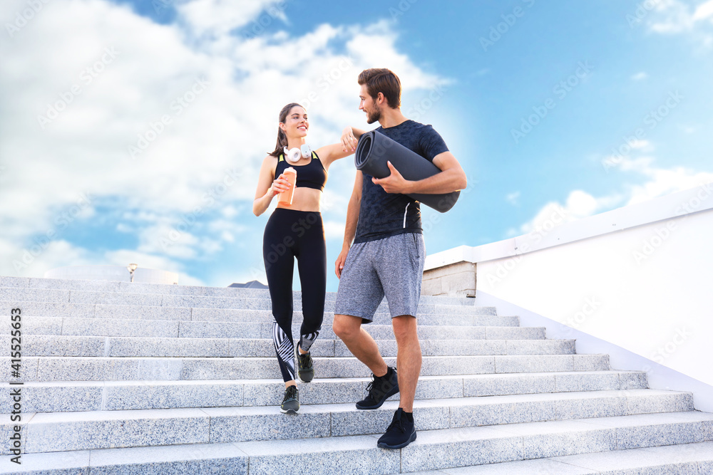 Fototapeta premium Young couple in sportswear going down the stairs after exercising outdoors.