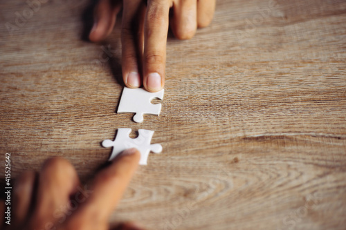 Closeup hand of man connecting jigsaw puzzle with sunlight effect, Business solutions, success and strategy concept	 photo