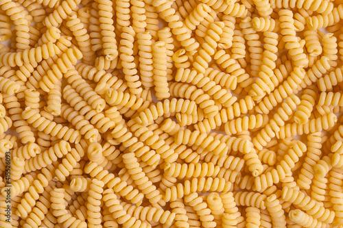 Raw durum wheat pasta, fusilli background. Top view