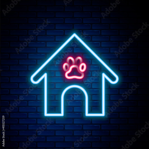 Glowing neon line Dog house and paw print pet icon isolated on brick wall background. Dog kennel. Colorful outline concept. Vector.