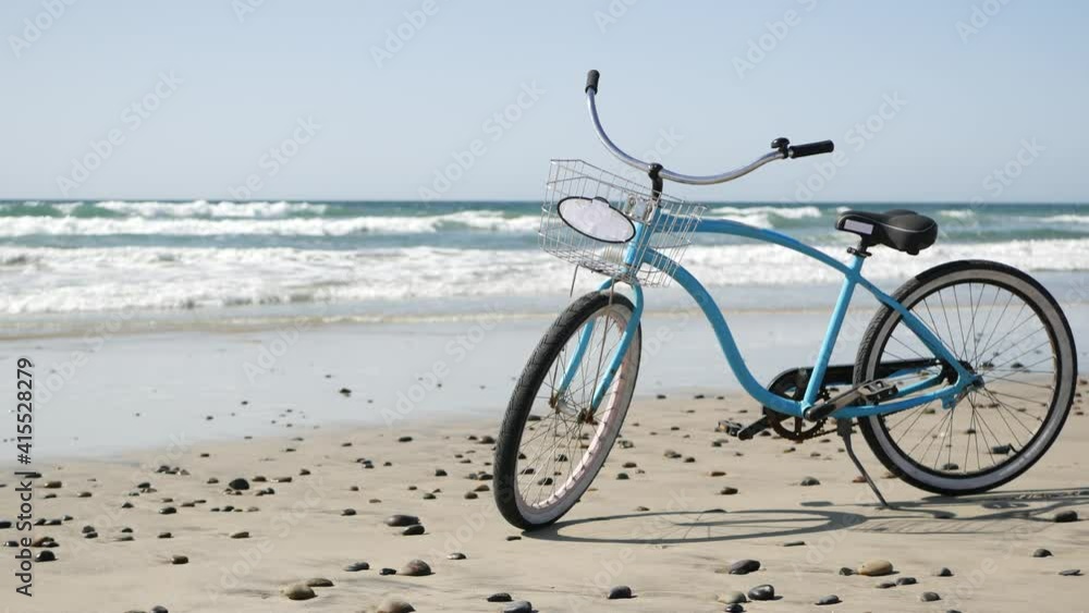 Blue bicycle, cruiser bike by ocean beach pacific coast, Oceanside California USA. Summertime vacations, sea shore. Vintage cycle on sand. Clear sky and water waves. Waterfront summer near Los Angeles Blue bicycle, cruiser bike by ocean beach pacific coast, Oceanside California USA. Summertime vacations, sea shore. Vintage cycle on sand. Clear sky and water waves. Waterfront summer near Los Angeles