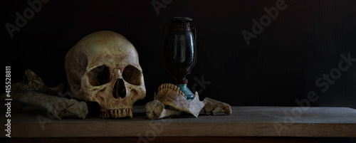 Skull and Jaw with old lantern on the plank and dark background