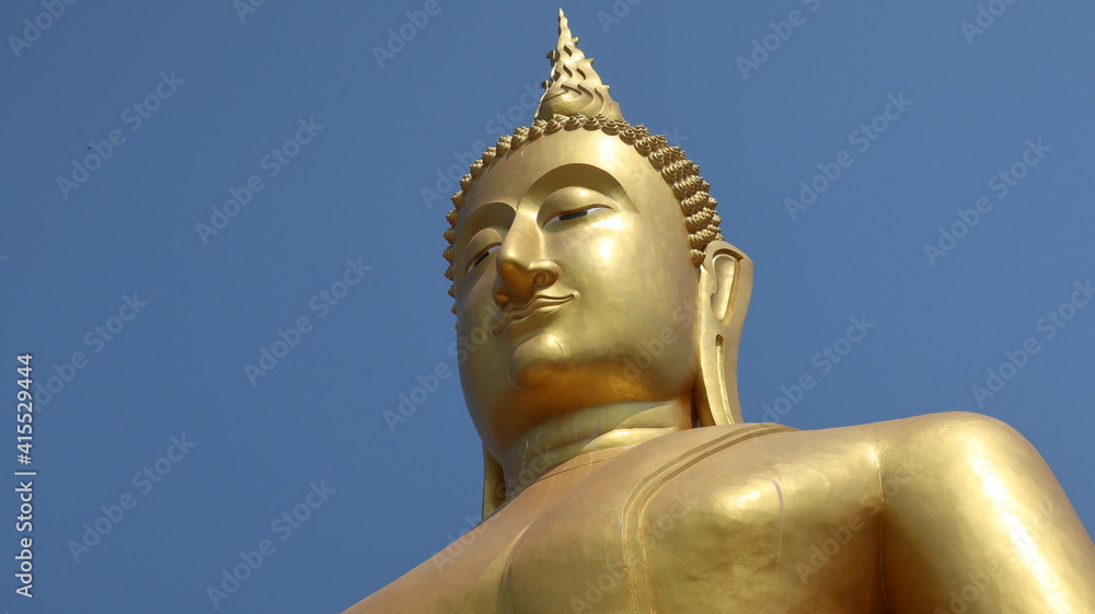 Buddha statue soars isolated into blue sky Buddha statue soars isolated into blue sky
