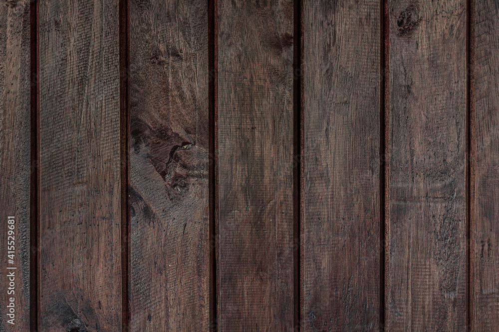 Fototapeta premium Texture of rural stained exterior vertical oak planks of country shed. Old dirty rough siding of gnarled surface wooden paneling. Rustic veined facing lumber fence of hard boards for 3D style design
