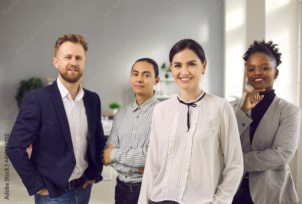 Business collaboration and team of mixed race specialists concept. Smiling positive office worker of various nationalities standing in team looking at camera together in office Business collaboration and team of mixed race specialists concept. Smiling positive office worker of various nationalities standing in team looking at camera together in office