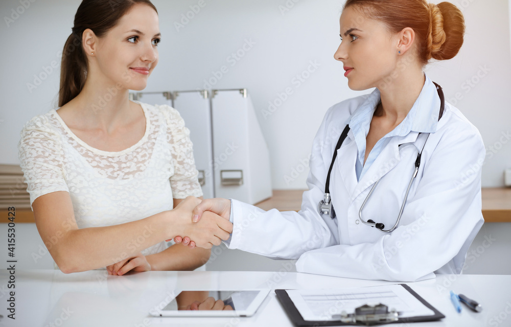 Woman-doctor reassuring her female patient while sitting at the desk. Medicine concept Woman-doctor reassuring her female patient while sitting at the desk. Medicine concept