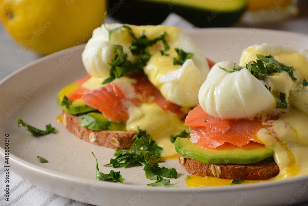 Eggs Benedict with smoked salmon, avocado slices and hollandaise sauce