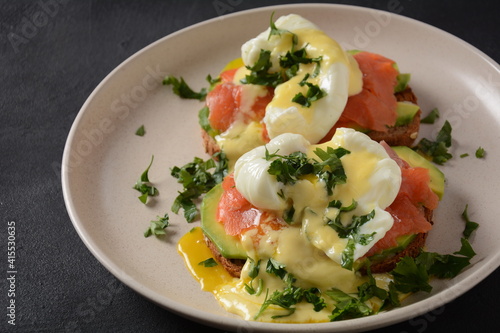 Eggs Benedict with smoked salmon, avocado slices and hollandaise sauce