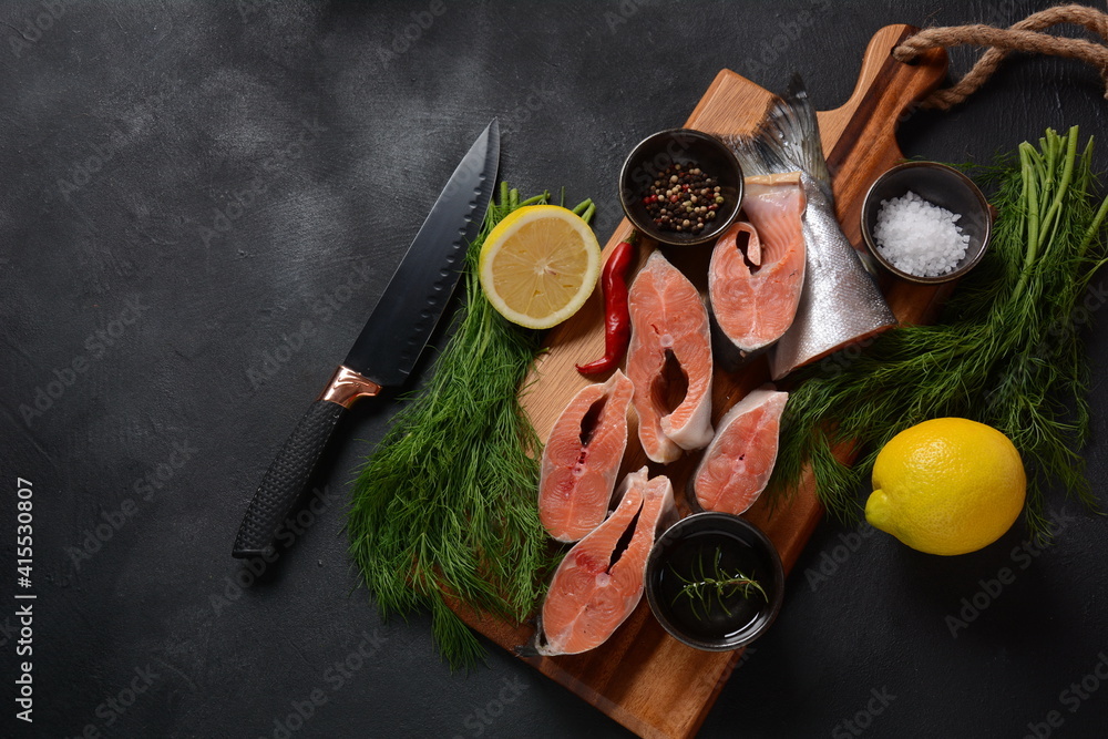 Fresh raw salmon steaks on board with salt, peppers, lemon, on black background, Fresh raw salmon steaks on board with salt, peppers, lemon, on black background,