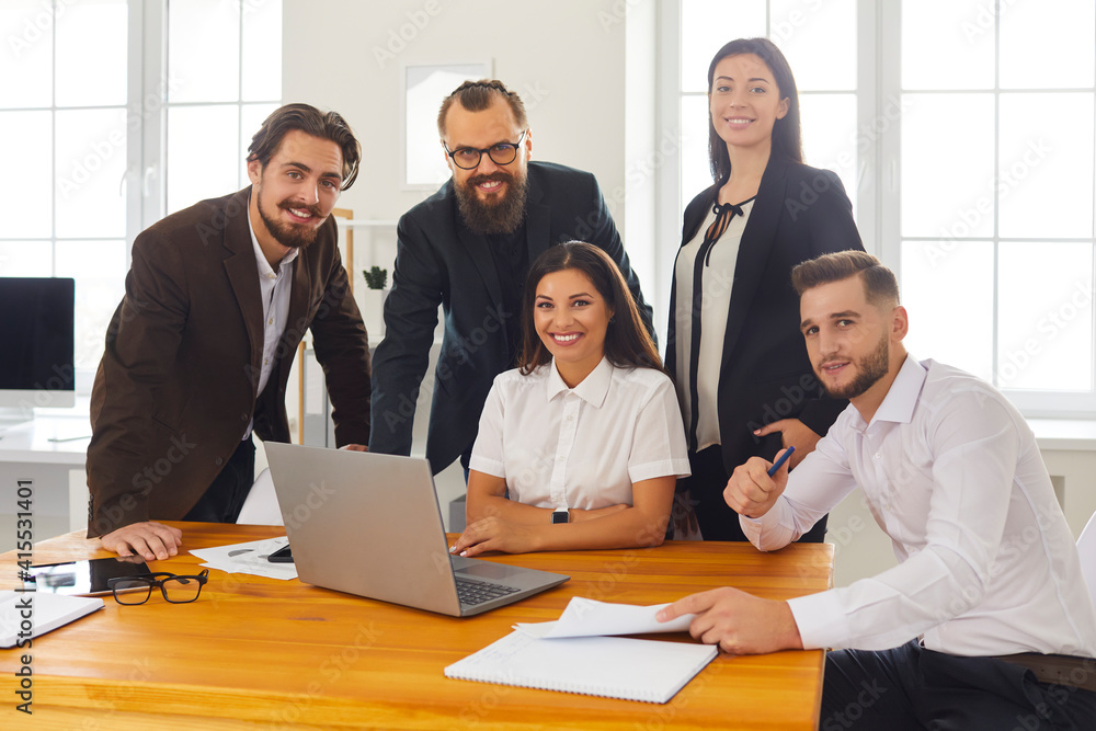 Obraz premium Group portrait of happy smiling business people near laptop in business center office.