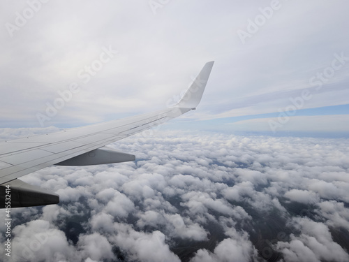 plane flies over cumulus clouds