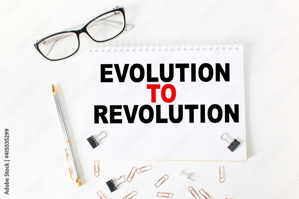 Notepad with inscriptions EVOLUTION TO REVOLUTION on a white background. business concept. Notepad with inscriptions EVOLUTION TO REVOLUTION on a white background. business concept.