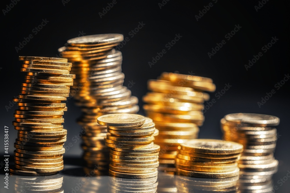 Large pile of coins against dark background Large pile of coins against dark background