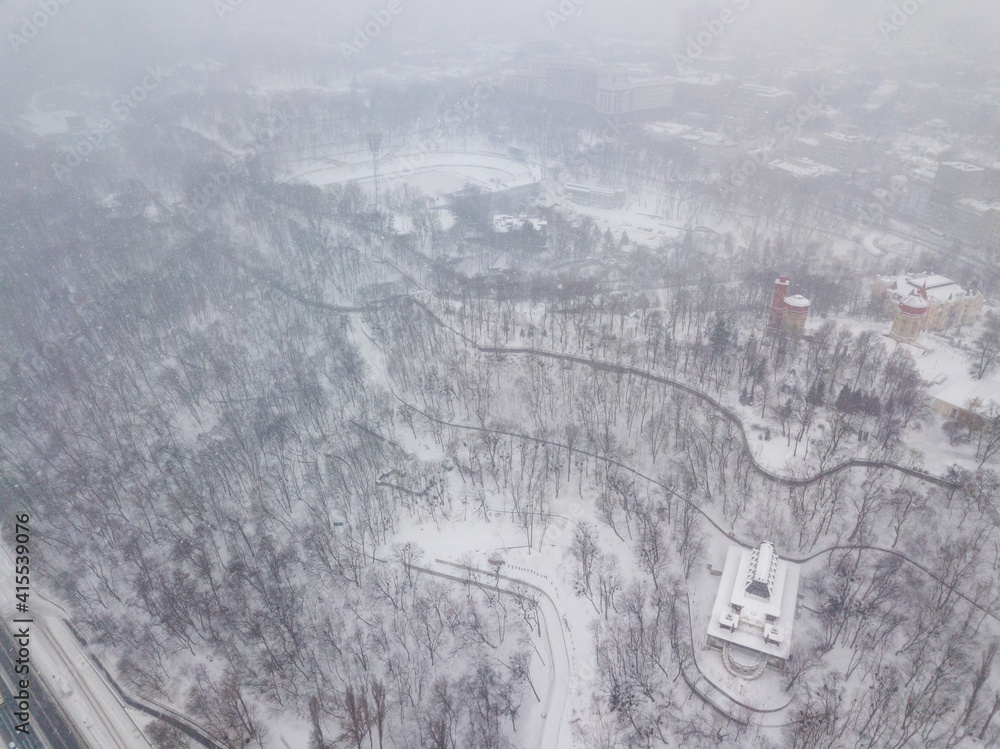 Obraz premium Snowy Kiev in a snowstorm, blizzard. Aerial drone view. Winter cloudy morning.