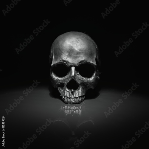 Spooky dark black skull aginast dark background