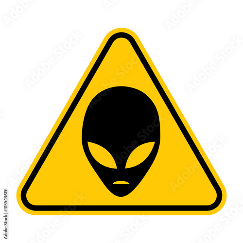Aliens warning road sign. Vector illustration of yellow triangle warning sign with black alien head icon inside. Caution UFO activity area. Alien abduction symbol.