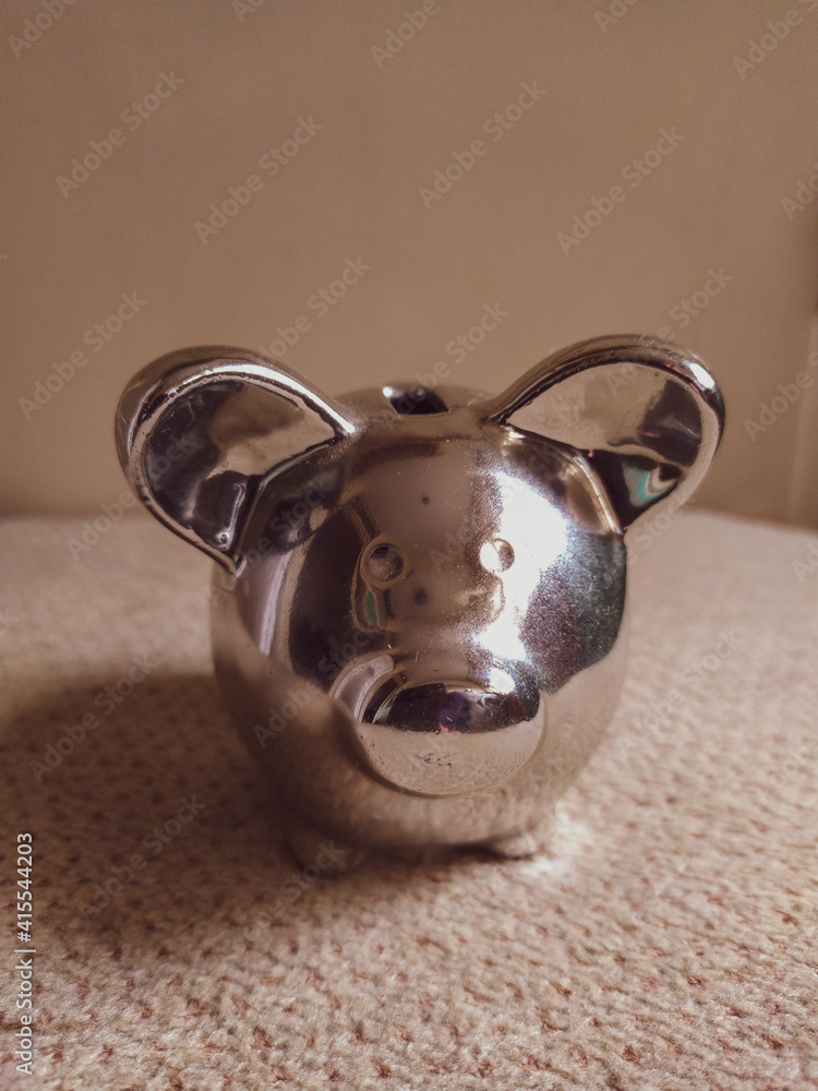 Vertical shot of a small silver pig cashbox on the - obrazy, fototapety, plakaty 