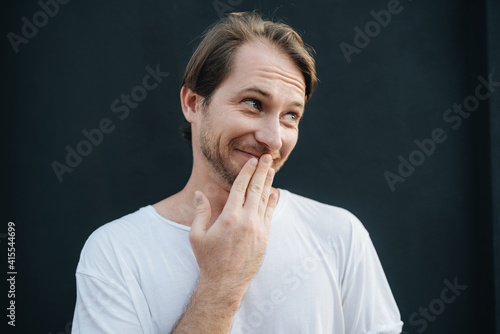 Foto Portrait of a shamed young man covering his mouth with hands
