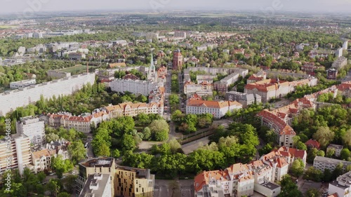 Aerial shot of a green roundabout in city. Busy street in a modern, beautiful city. Drone view of Wrocław natural neighborhood.