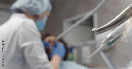 Doctor dentist treating teeth of beautiful young woman patient.