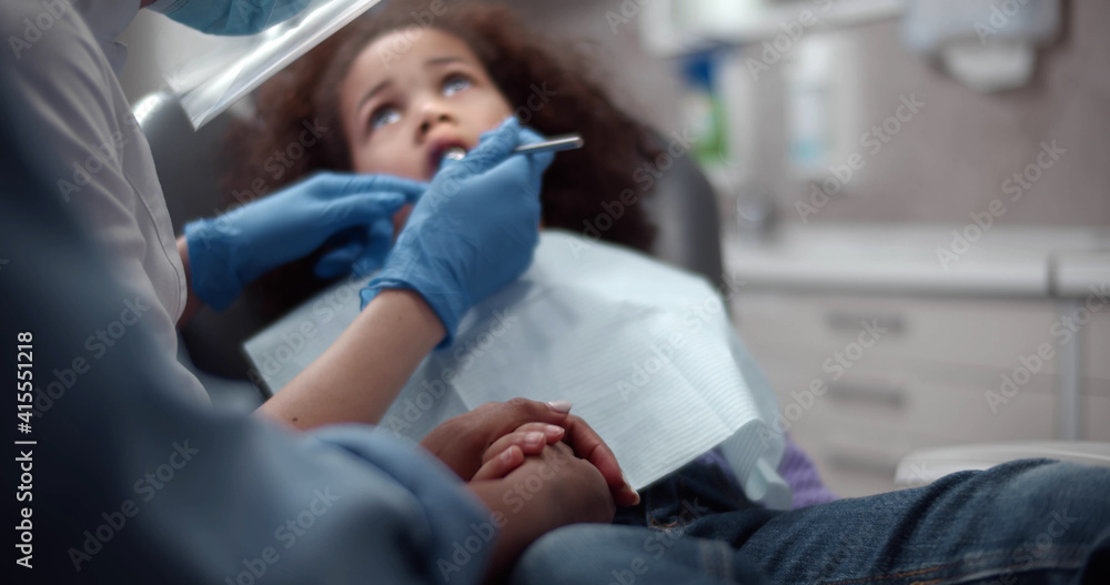 African little girl sitting in dentist chair during teeth checkup African little girl sitting in dentist chair during teeth checkup