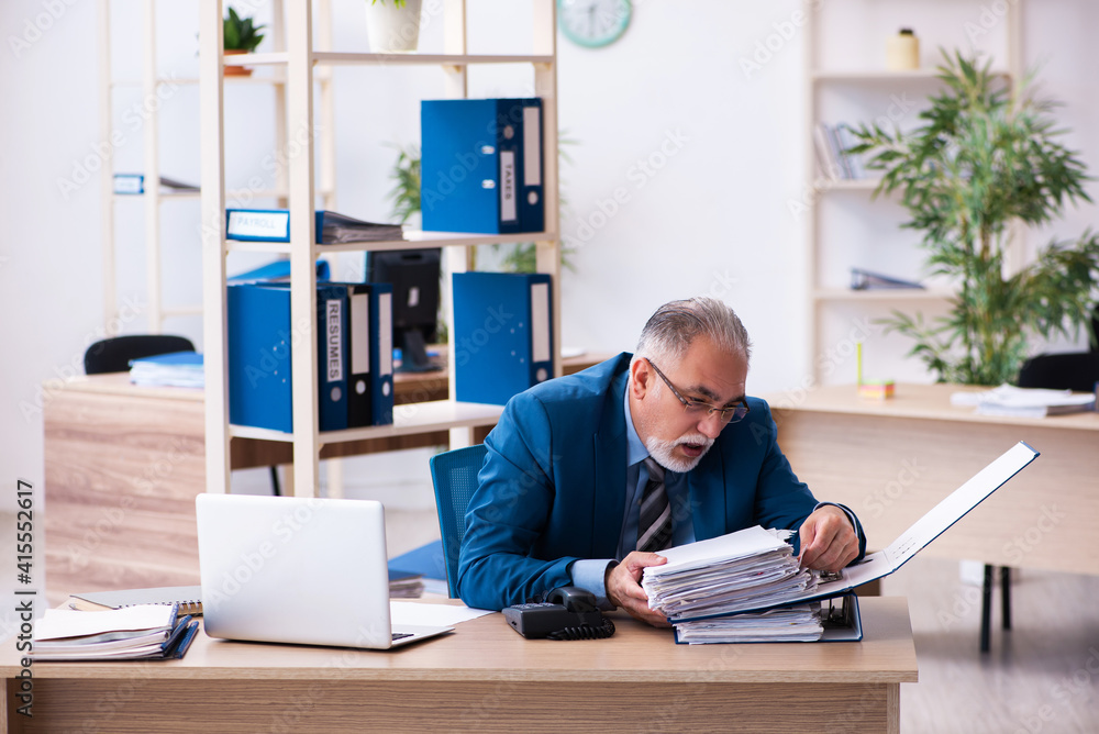 Old male bookkeeper unhappy with excessive work at workplace Old male bookkeeper unhappy with excessive work at workplace