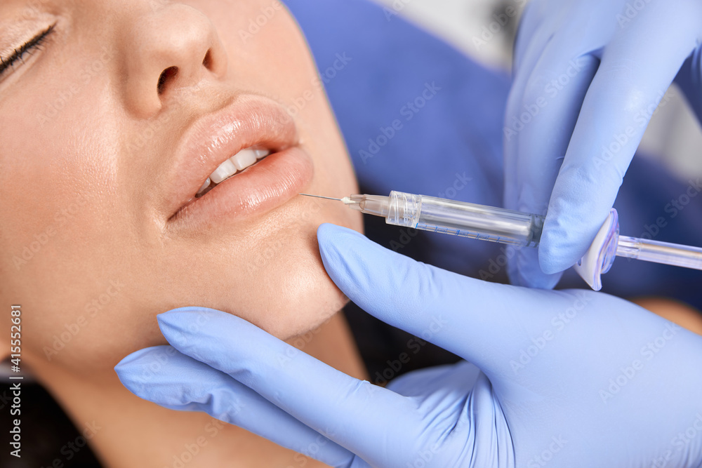 Professional cosmetologist is doing procedures for client in light cabinet Professional cosmetologist is doing procedures for client in light cabinet