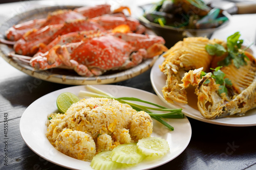 crab-shaped pork fried rice and steamed blue or horse crab with fried fish in dish and baked mussels on table for fresh seafood set to lunch and dinner with iodine and cholesterol food at restaurant