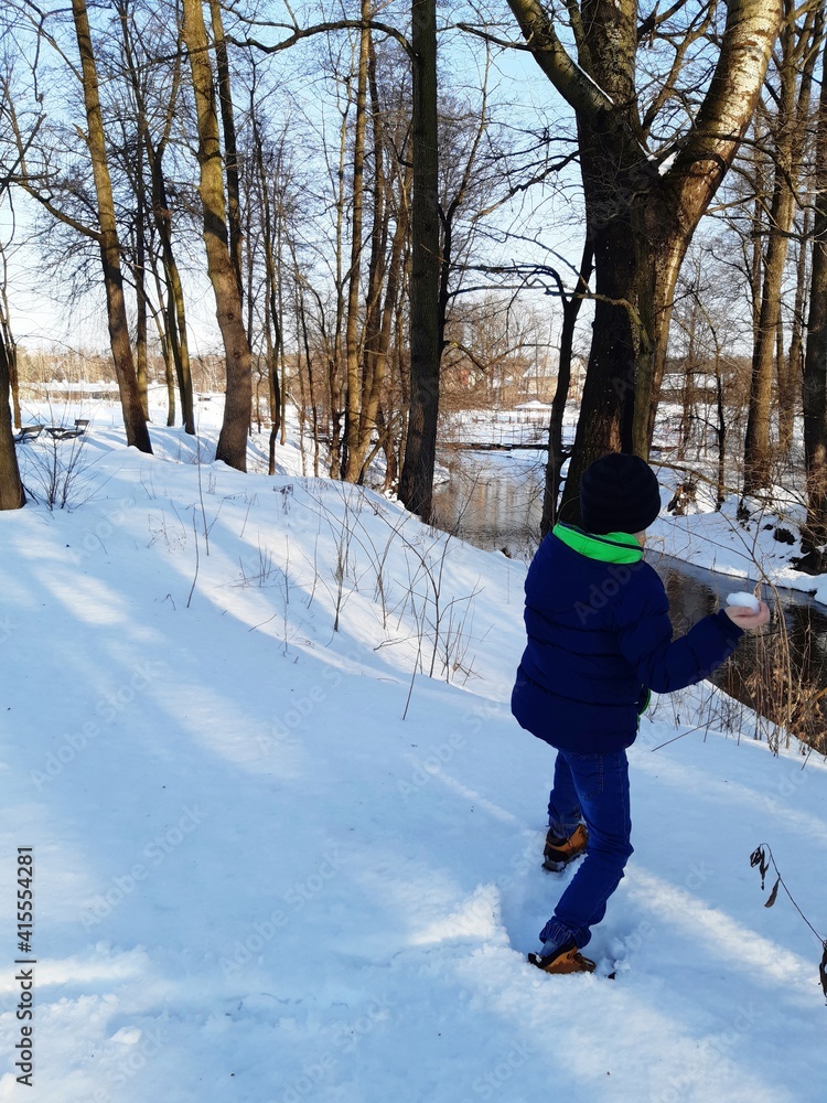 a series of 6 pictures shows a boy throwing snowballs. The picture of winter by the river, snow, naked trees, sun.