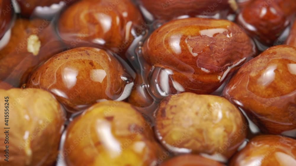 Honey pouring into bowl of hazelnuts in slow motion. Honey pouring into bowl of hazelnuts in slow motion.