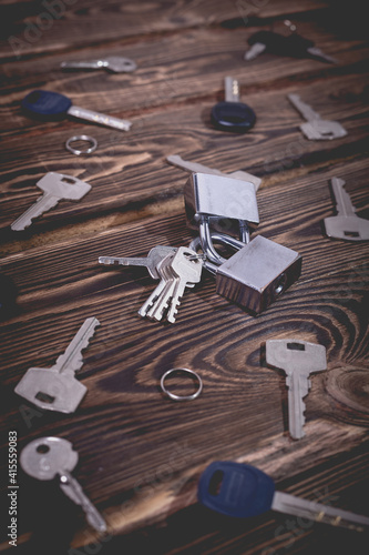 Studio photo of a lock and keys on a wooden background.