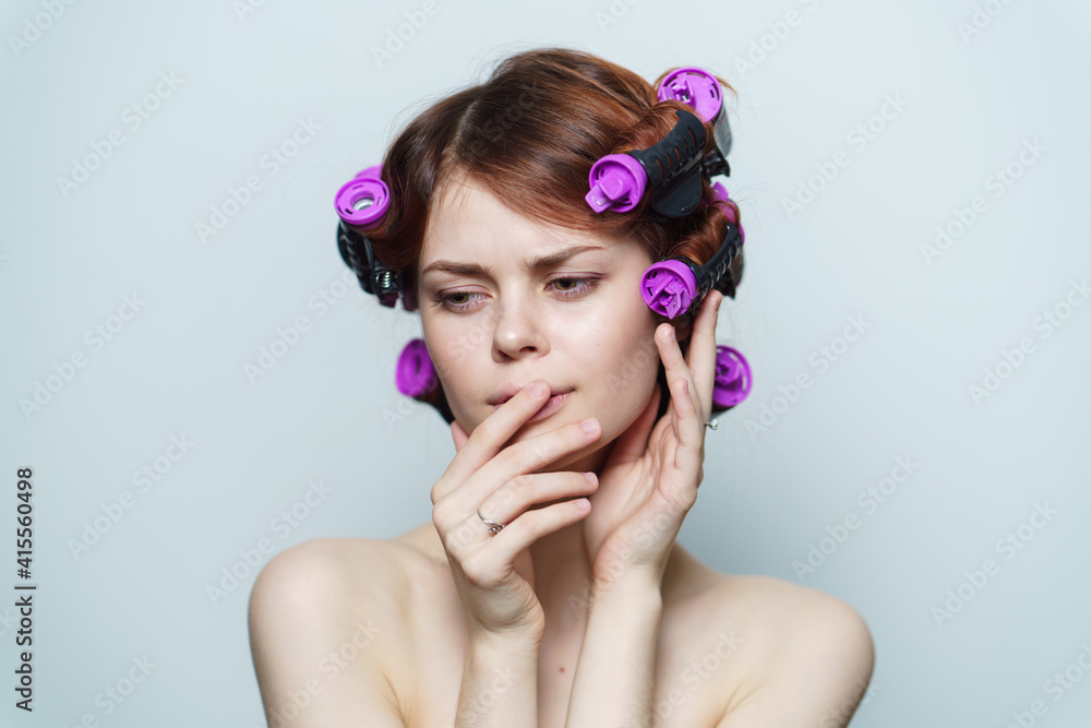 wind curls of hair purple curlers on the head of a red-haired woman