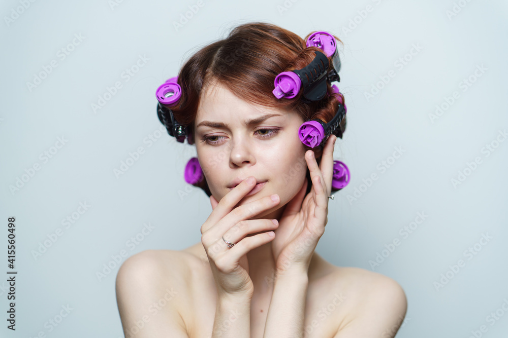 wind curls of hair purple curlers on the head of a red-haired woman wind curls of hair purple curlers on the head of a red-haired woman