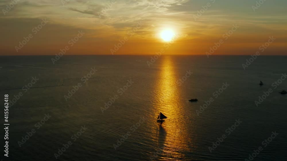 Sunset over the sea surface with sailing yachts from above Boracay, Philippines. Reflected sun on a water surface. Sunset over ocean. Seascape, Summer and travel vacation concept Sunset over the sea surface with sailing yachts from above Boracay, Philippines. Reflected sun on a water surface. Sunset over ocean. Seascape, Summer and travel vacation concept