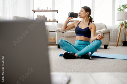 Slim woman drinks water, online fitness training