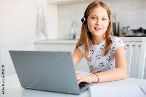 Female student at home in front of a laptop monitor. She does teacher-led lessons online.