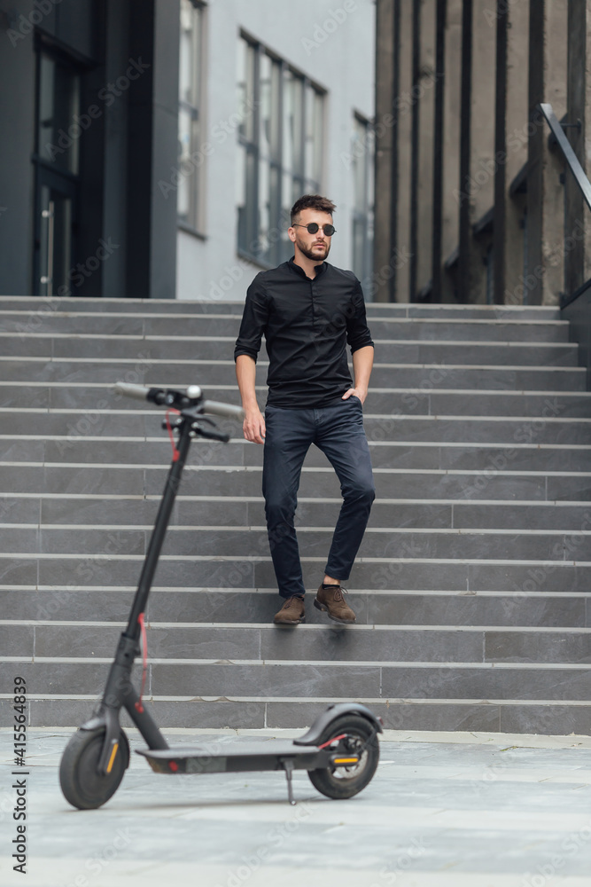 Young man going downstairs to his electric scooter in urban background Young man going downstairs to his electric scooter in urban background