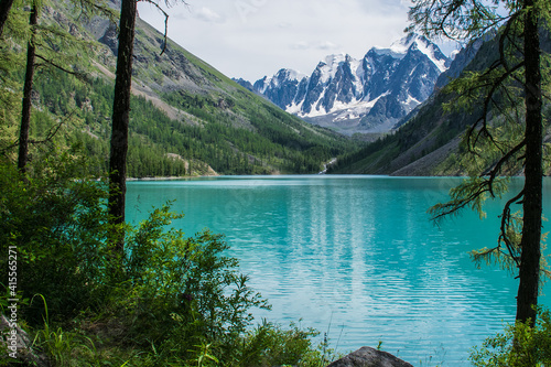 The pearl of the Altai Mountains, Lake Shavlo, with three glacier-covered peaks towering above it, is a Fairy tale, a Dream and a Beauty that is reflected in the lake water. photo